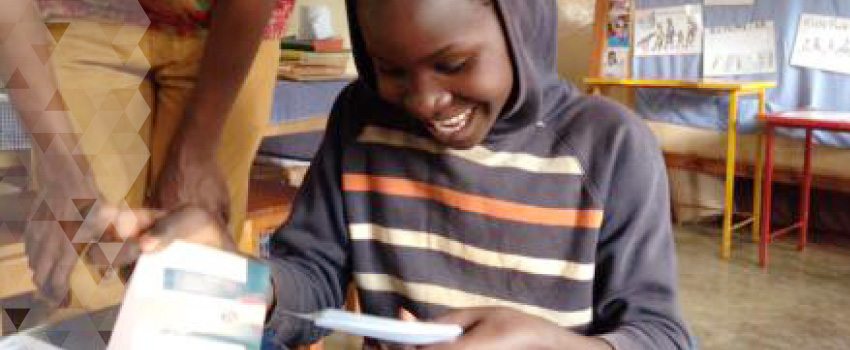 A child looks at her photos for the first time. She is smiling.