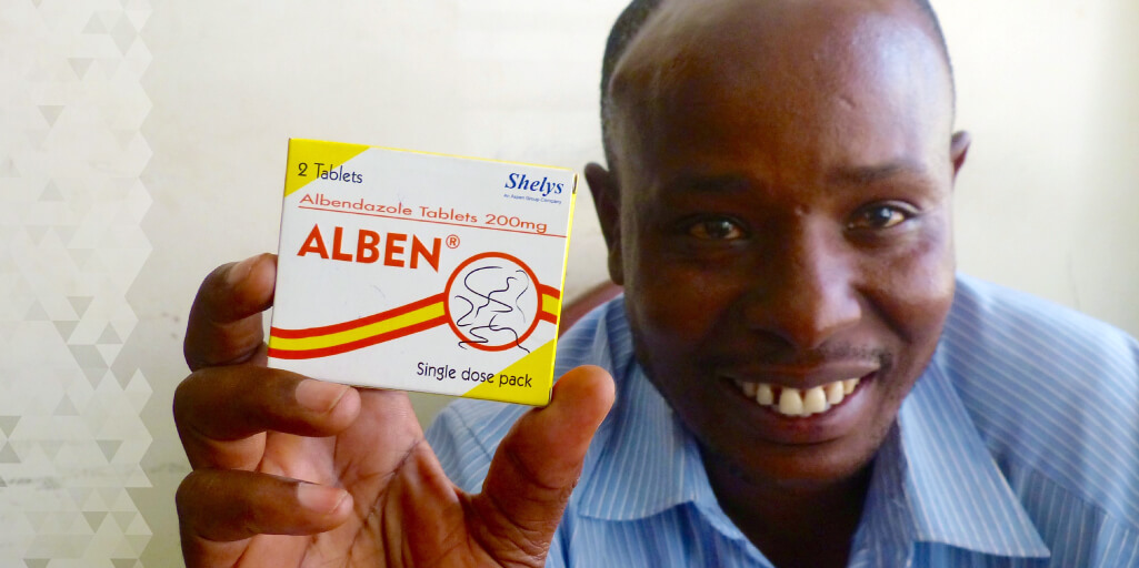 Godson distributes de-worming medication.