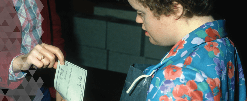 A young woman looks at her paycheck.